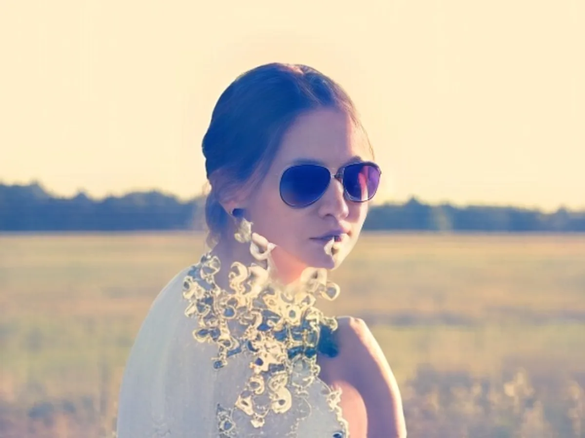 Low-resolution photo of a woman in sunglasses in a field, after enhancement