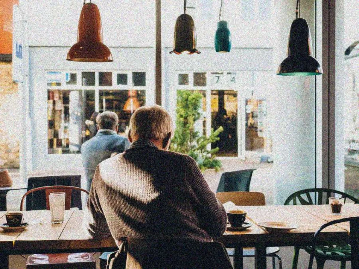 Grainy photo of a man in a cafe, before enhancement